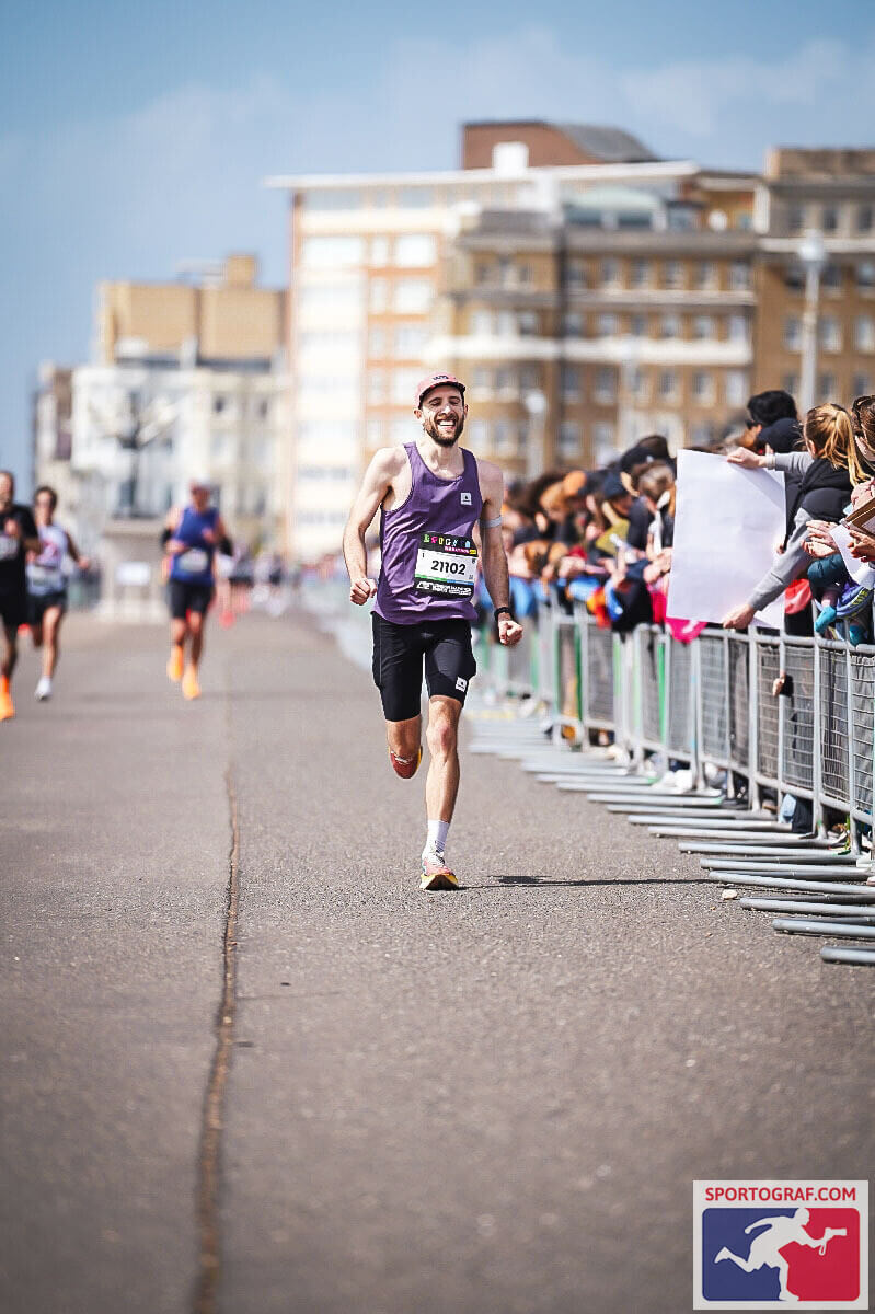 Me on the finishing straight, smile/grimacing, with fists pumped, e several runners in the background