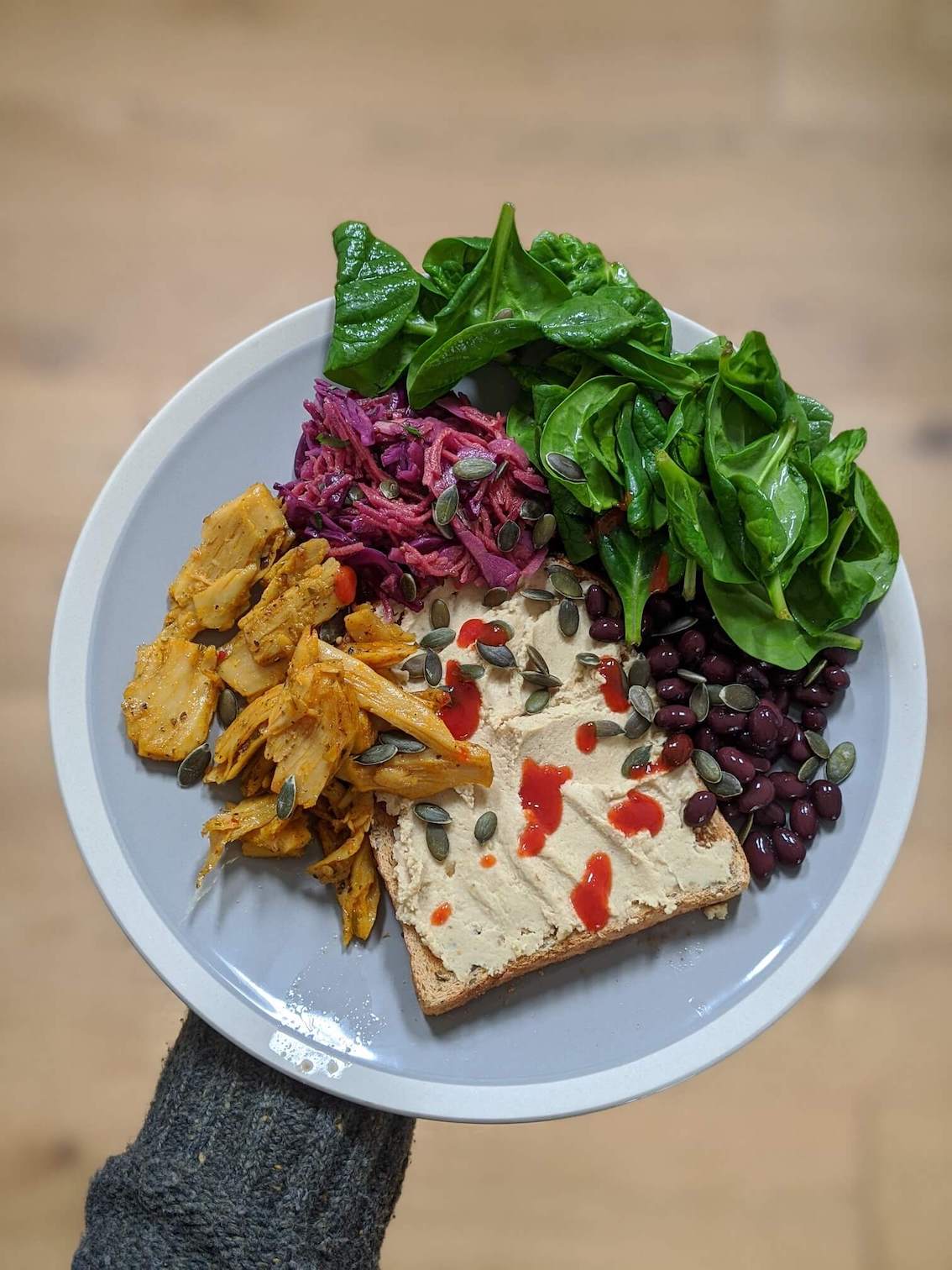 Hummus, black beans, kebab, coleslaw spinach on toast