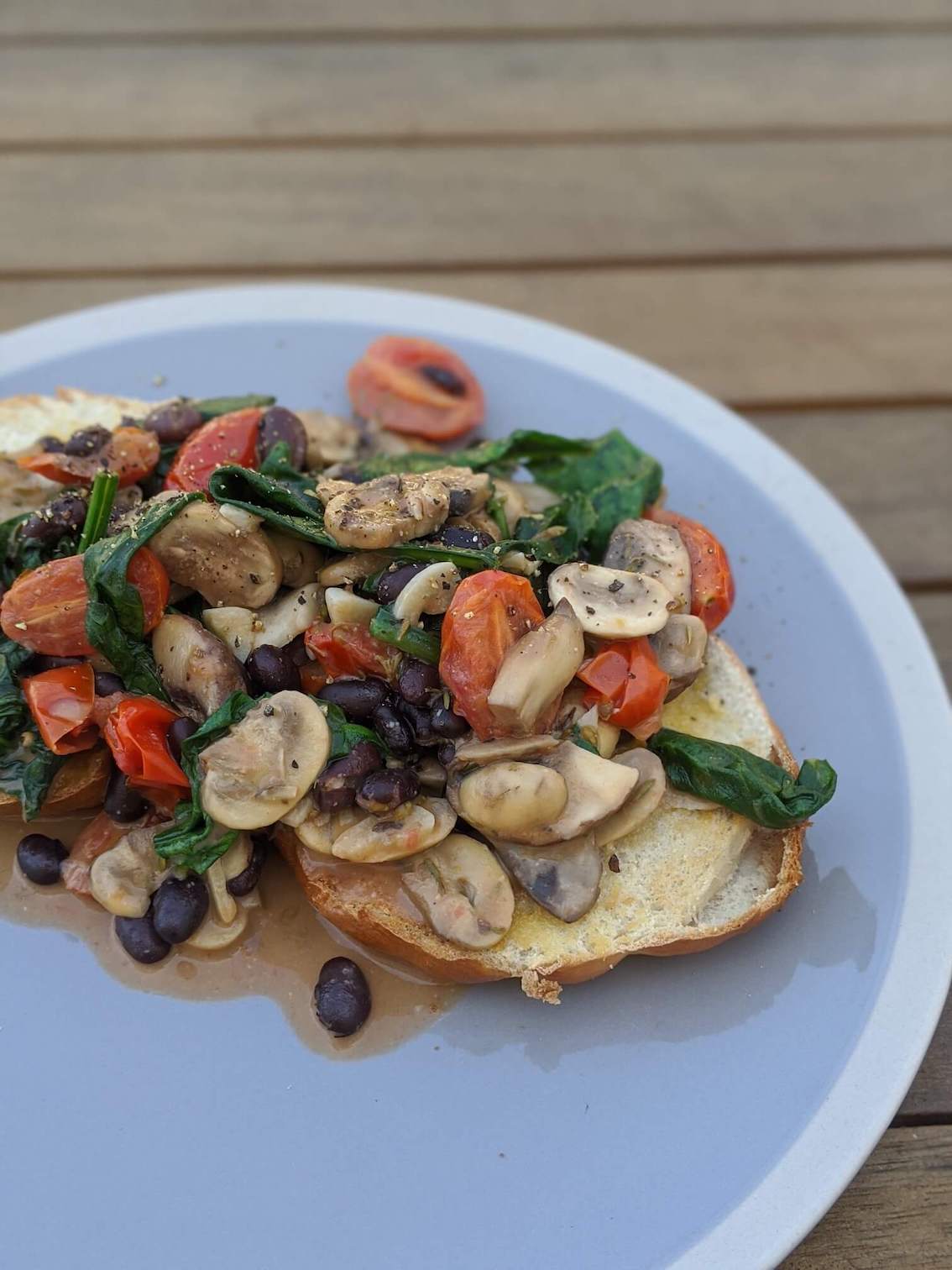 Miso, mushroom, coconut, spinach, tomatoes and black beans on a bagel