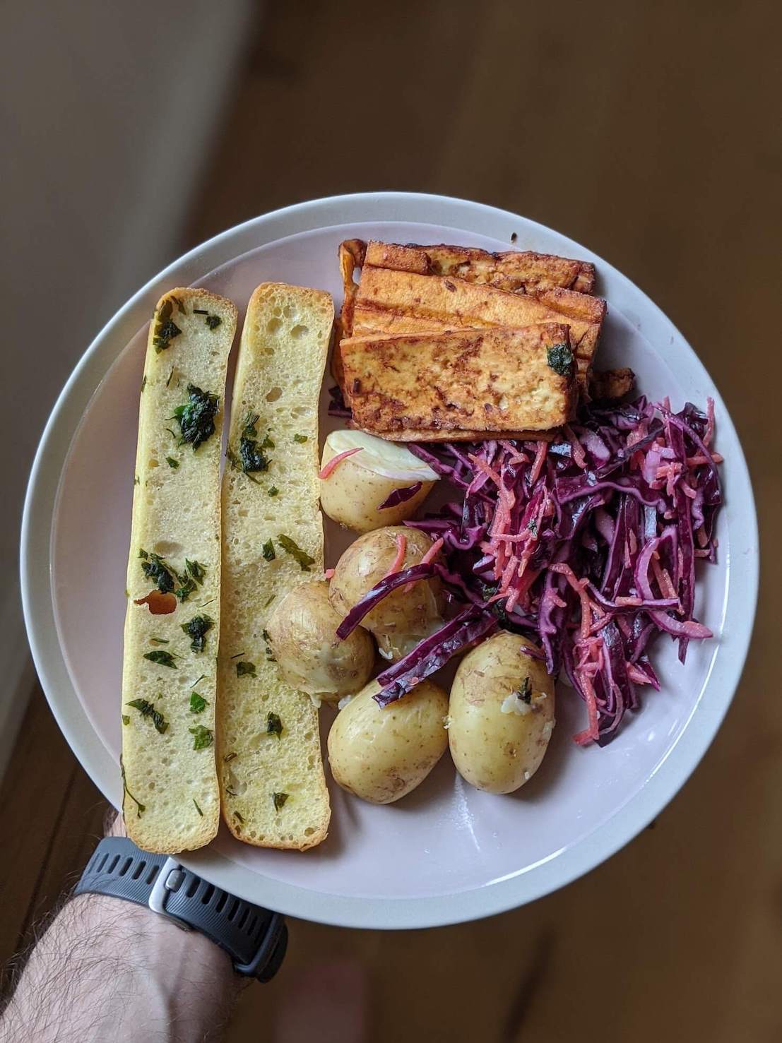 New potaotes, coleslaw, garlic bread sticks, marinated roasted tofu