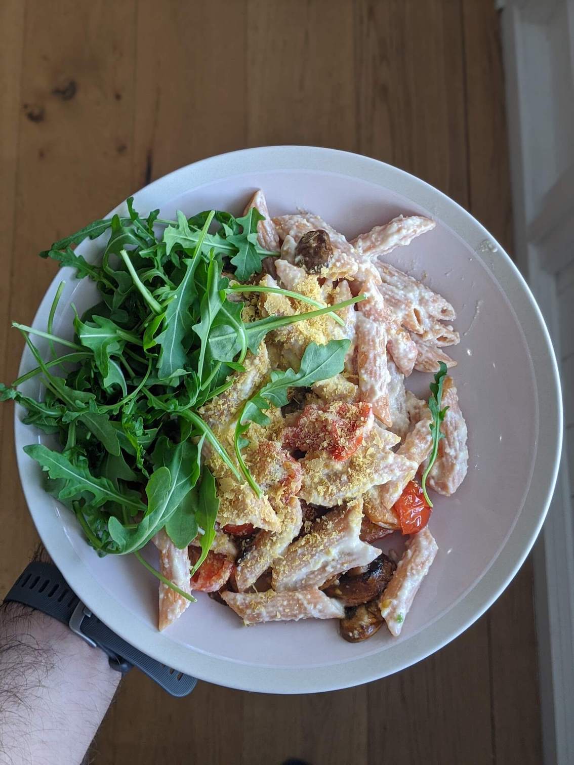 Red lentil pasta with al fredo sauce, fried mushrooms and cherry tomatoes, rocket